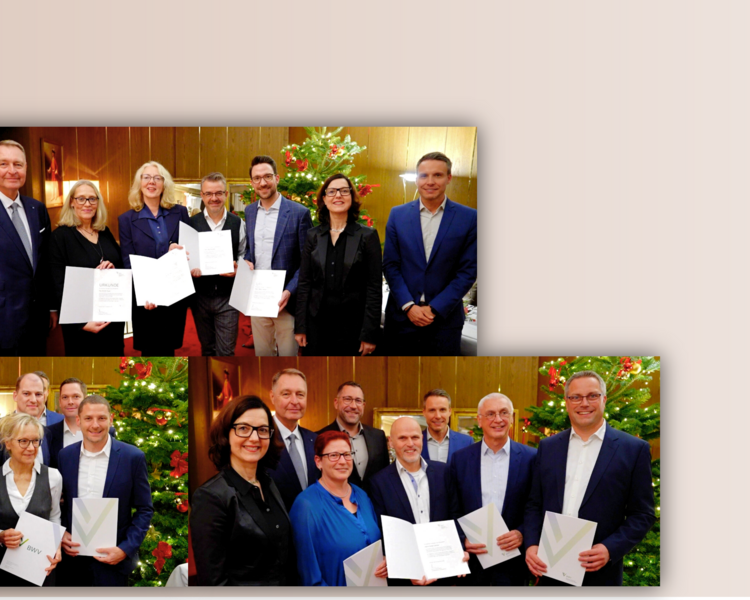 Mehrere Gruppen von Personen stehen zusammen und halten Urkunden in den Händen. Sie lächeln und scheinen stolz auf ihre Auszeichnungen zu sein. Im Hintergrund sind festliche Dekorationen zu sehen.